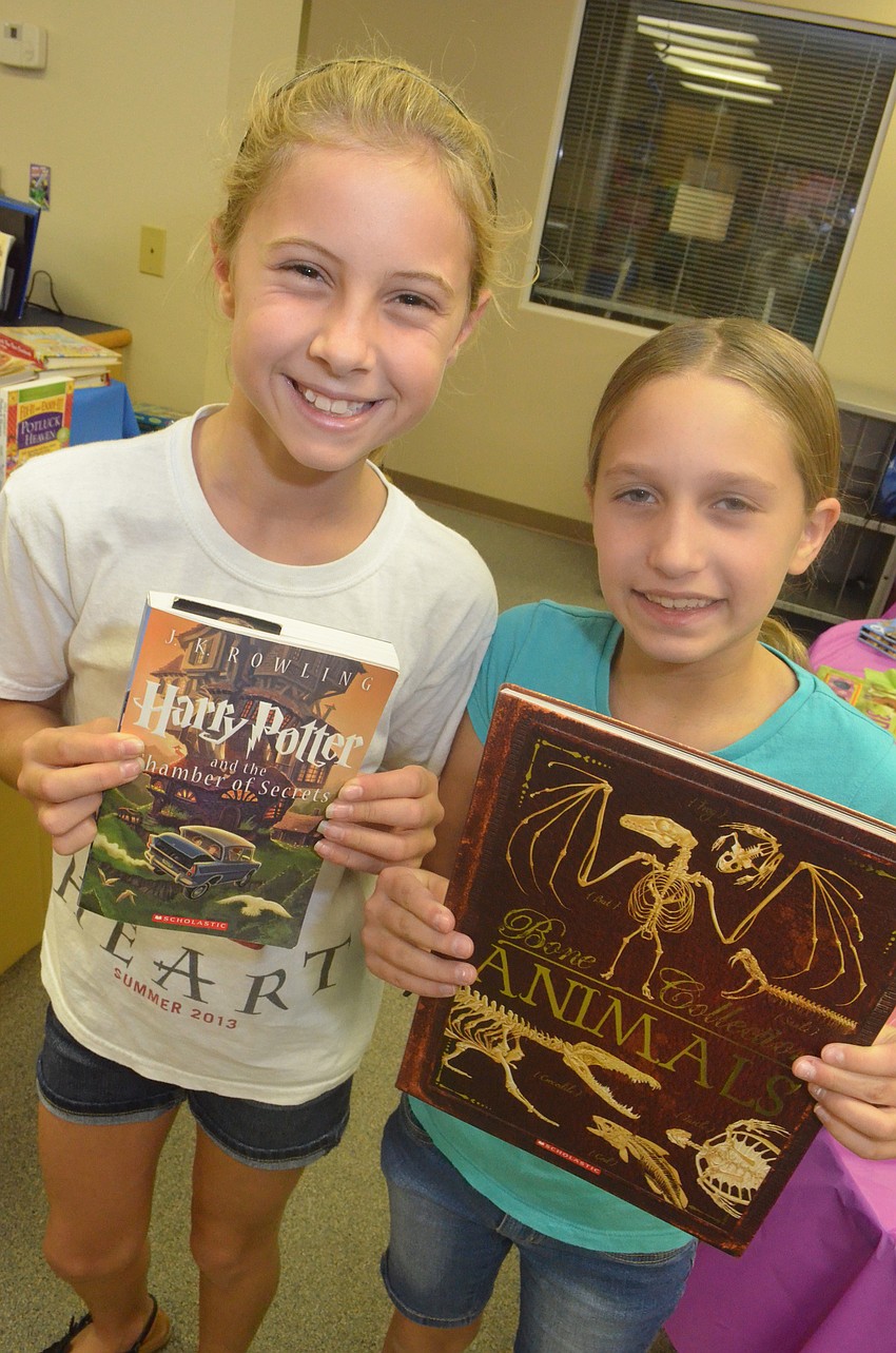 Jaena Shamp, 10, and Mackenzie Stutzman, 10, hang out and look through books at the book fair.