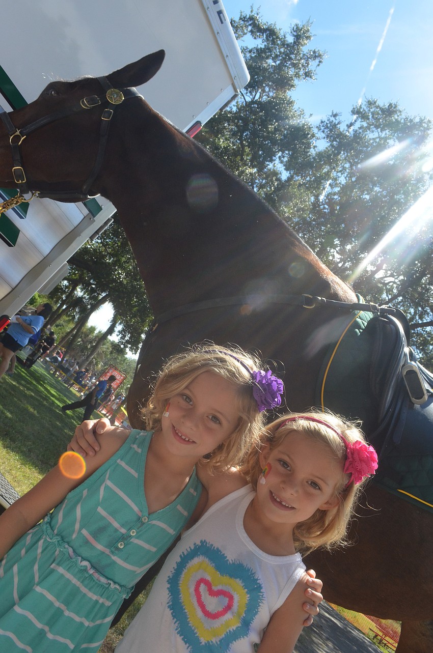 Twin sisters Lily and Isabel Dibble, 5, check out the police horse.