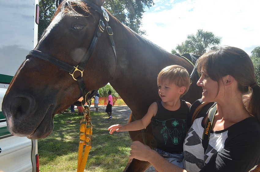 Reese Garrett, 2, and his mom Kelly pet the police horse.