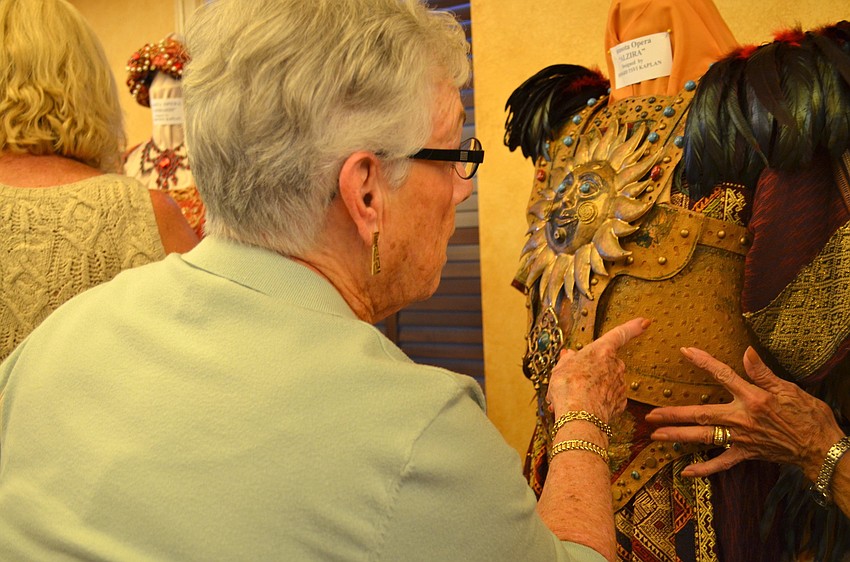 Member of the Bradenton Opera Guild Sheila Varady marvels at one of the Sarasota Opera costumes head dresser Ruthie Engford Clark shows her. Three elaborate costumes were on display.