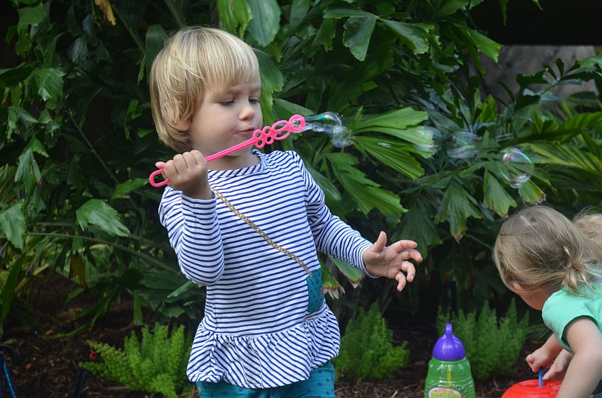 Amelia Hemmer blows bubbles at one of the gardenâ€™s play stations.