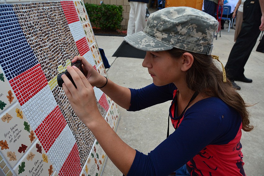 Student Chloe Sciarrone took a picture of the tile honoring her stepfather, veteran Christopher Schulte.