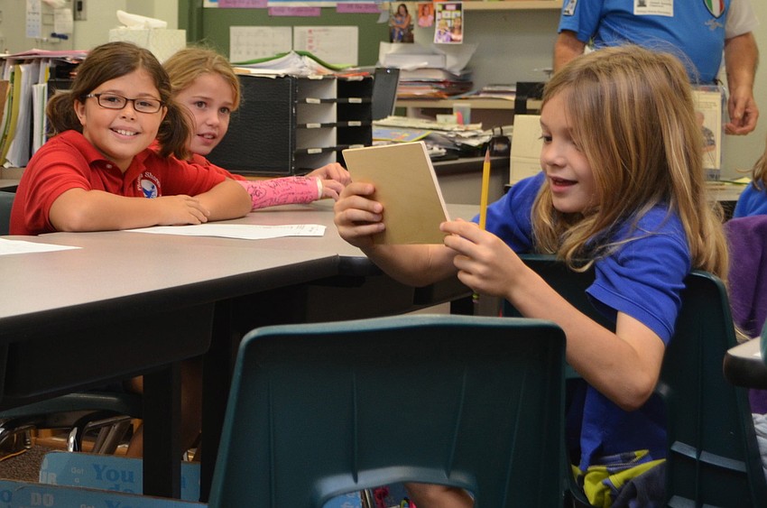 Amelia Malkin takes a look at the visuals Joseph Spinella passed around the classroom while presenting his book to the class.
