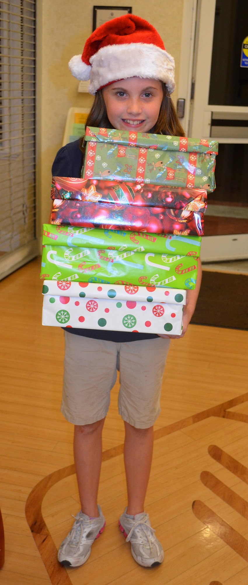 Nine-year-old Emilee Gately shows off her inner elf, donating already-wrapped boxes.