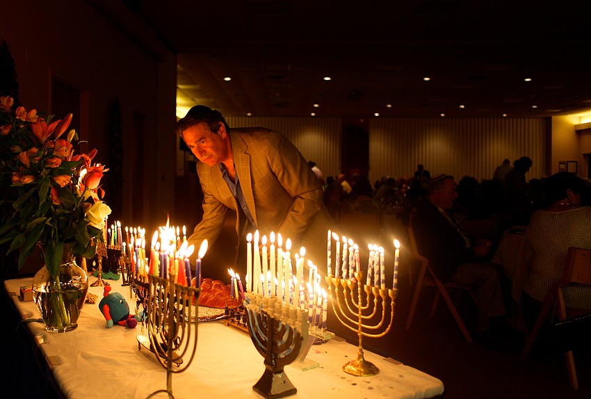 Rabbi Jonathan Katz lights a menorah.