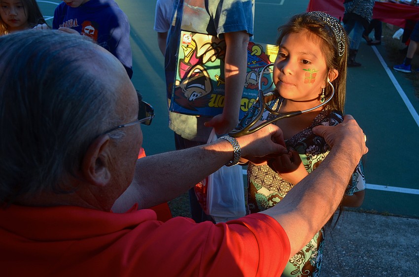 Dr. Glen Joshpe lets Arceli Garcia's, 7, hear her own heart beat.