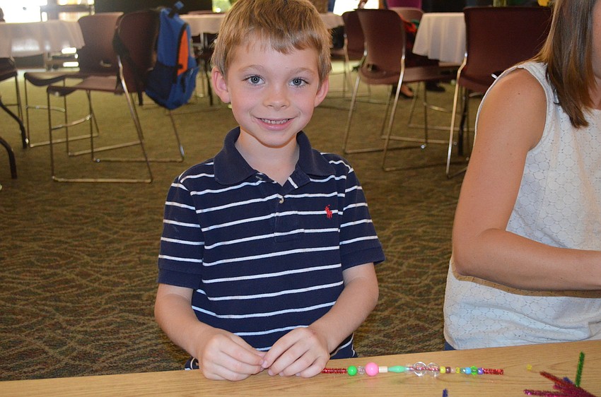 Jack Horn decorates a mini wreath with beads.
