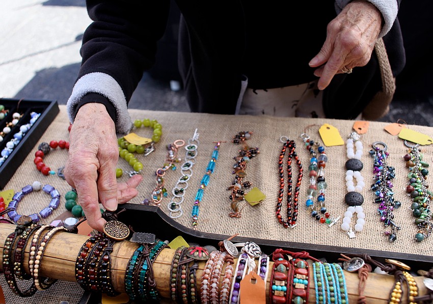 Polly MacFadden looks through bracelets at Z~Ro Strings booth.