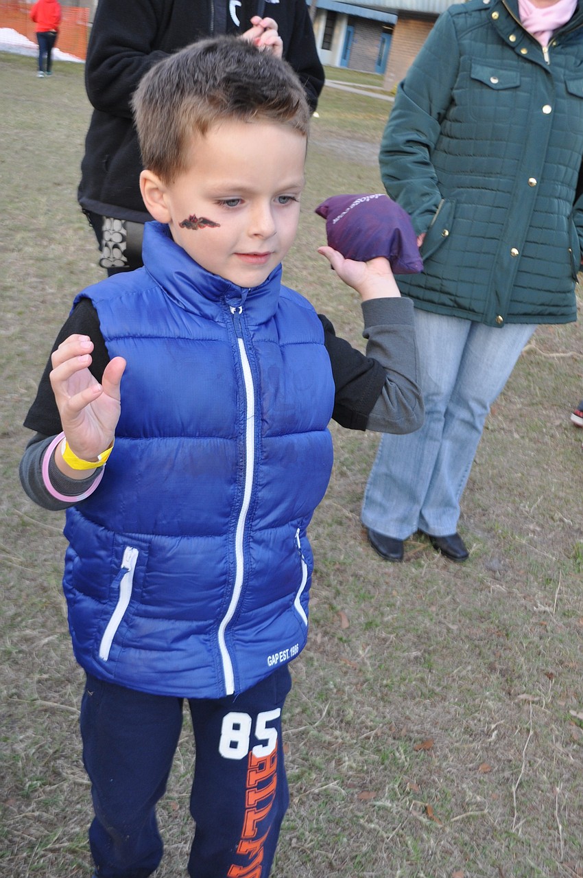 Ethan Chwojko, 6, scores twice in a game of corn hole.