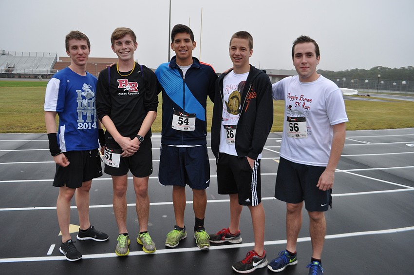 Track team members R.J. Brown, Mitchell McCormick, Alejandro Marquez, Luke Morris and Tyler Shanahan stretch before the race.