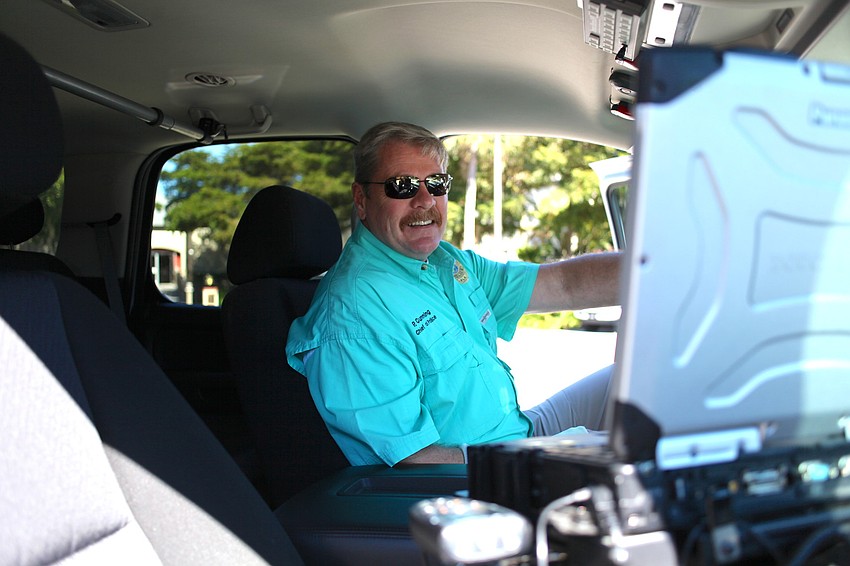 Chief Peter Cummings demonstrates receiving calls in his police vehicle.