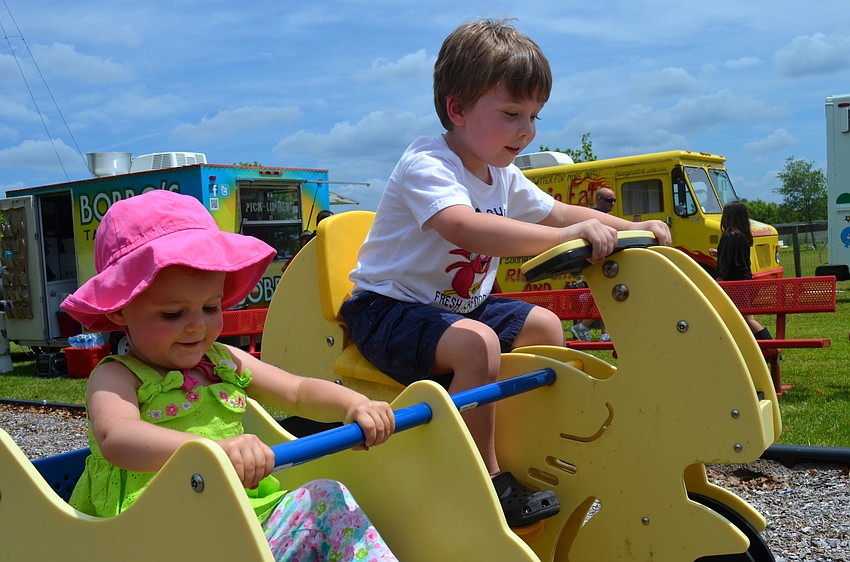 New friends, Delia Rateri, 2, and Brody Smith, 3, enjoy the playground.