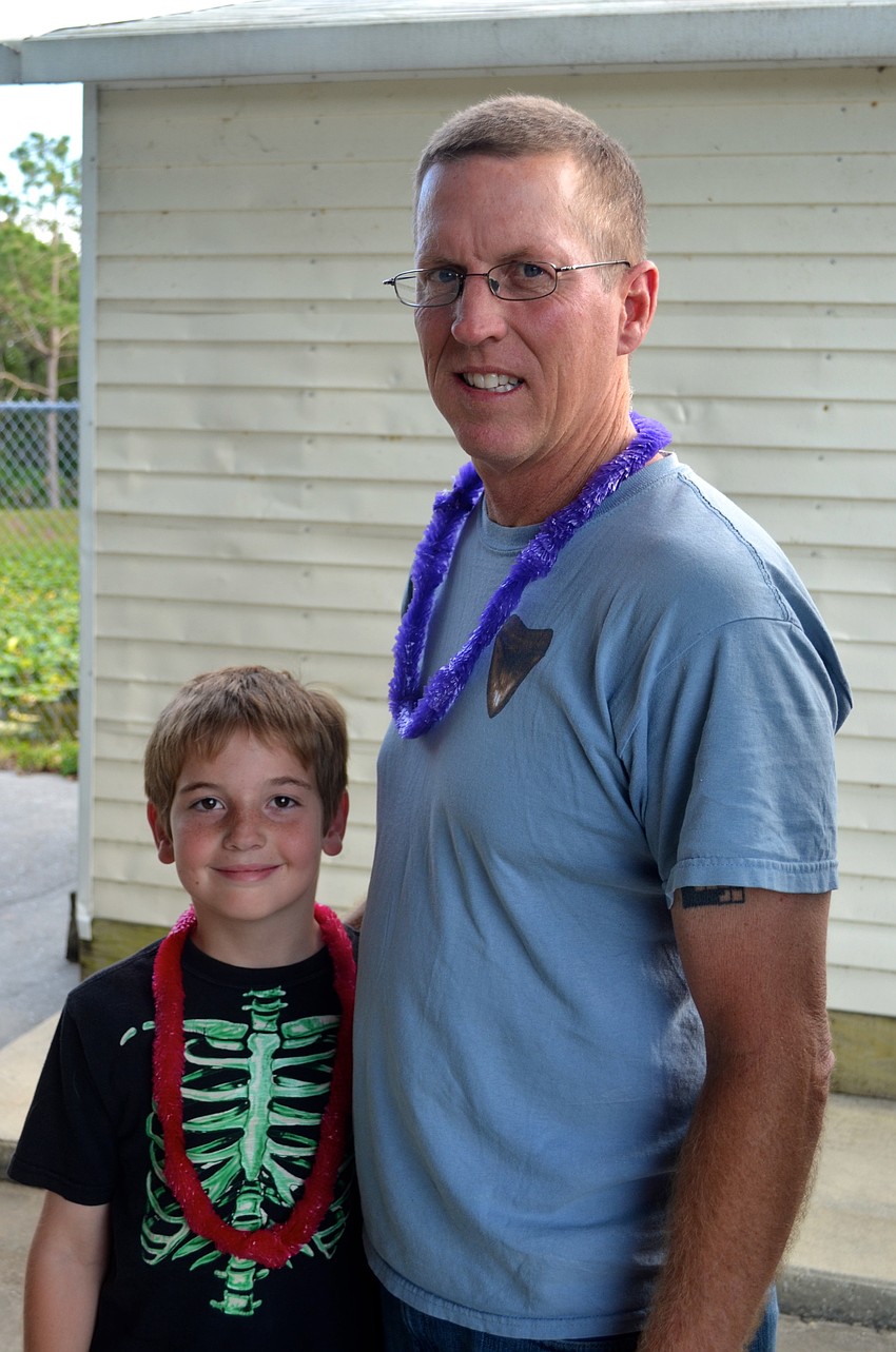 Nine-year-old Ty Dunn watches the dance team perform with his father, Tommy.