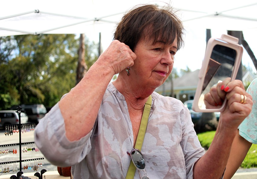 Linda Kelly tries on earrings at Z-Ro Strings.