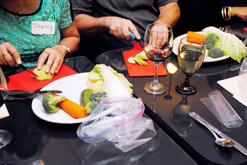 Students in Taste of Asiaâ€™s cooking class slice and dice vegetables.