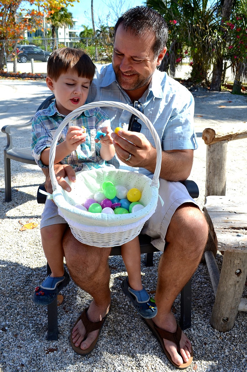 Greyson Savchuk, 4, and his father, Don, look through Greysonâ€™s basket after the hunt.