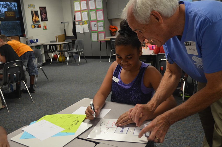 Volunteer Richard King helps Zionna Williams.