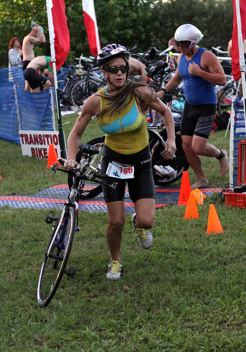 Deborah Pike, No. 166, runs with her bike down to the mounting area for the second portion of the sprint triathlon.