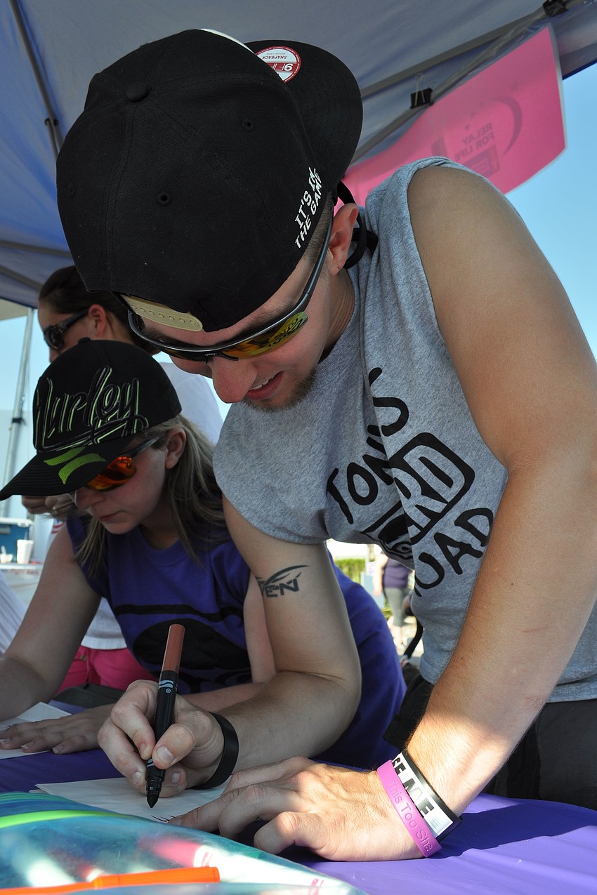 Drew Roberts readies a luminaria in honor of his great grandfather, Edward Anderson.