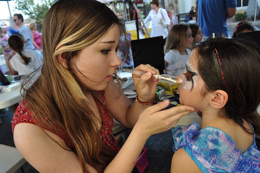 Britanie Mizell paints a cat face on Sofia Diaz, 7.