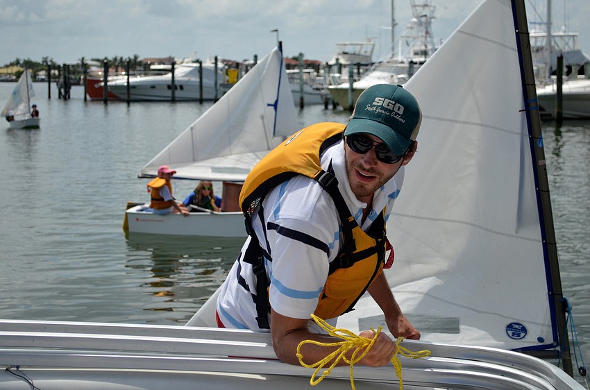 Sailing instructor Joseph Strickland pulls the campers to the dock.