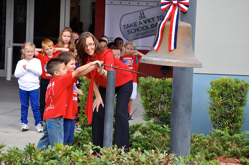 Maurio Hernandez, 6, and Ethan Owen, 4, help Assistant Principal Laura Campbell ring the Freedom Elementary bell.