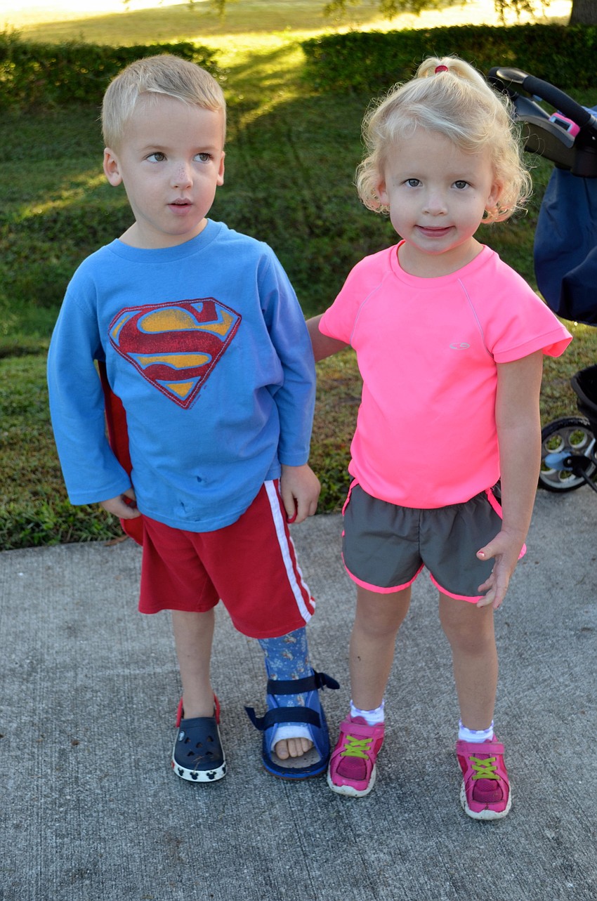 Three-year-old twins Parker and Hayden Bowles support their big brother and father who ran in the race.
