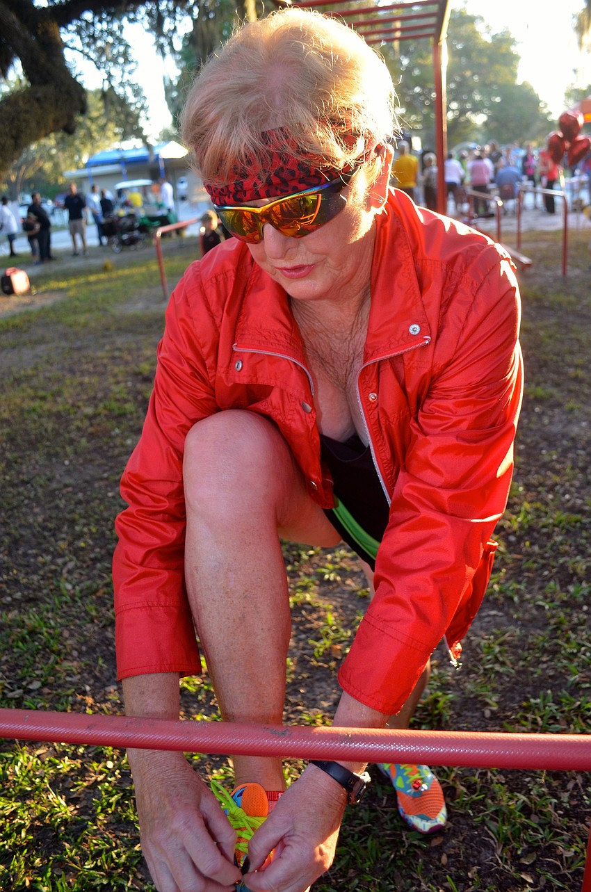 Judy Rettle, of the Fry Family Foundation, fastens bells to her shoelaces.