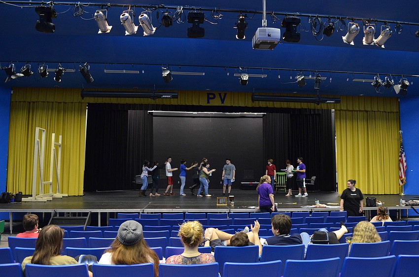 The students on stage practice conga line choreography