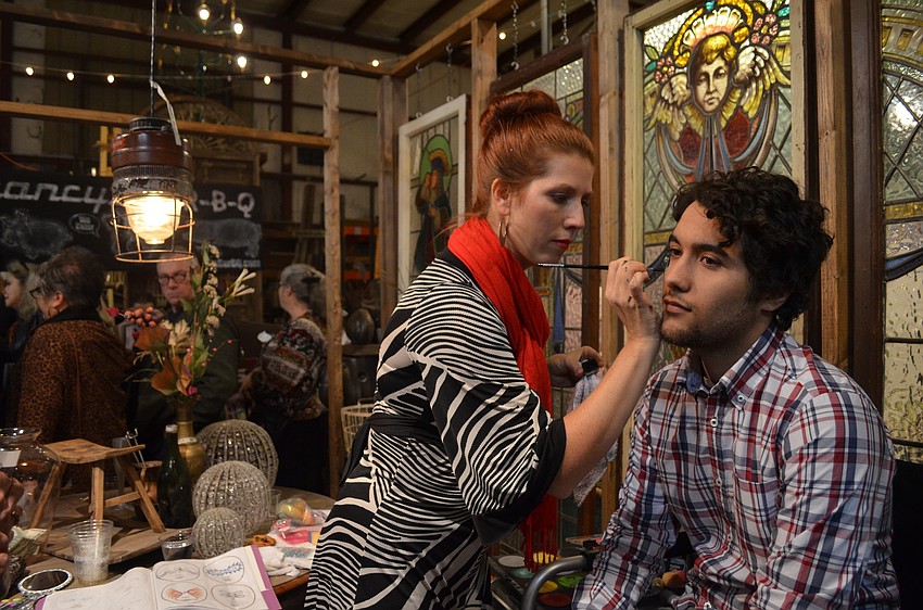 Erin Ernst paints Eric Navaâ€™s face.