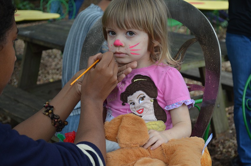 Isabella Carlson has her face painted with whiskers.