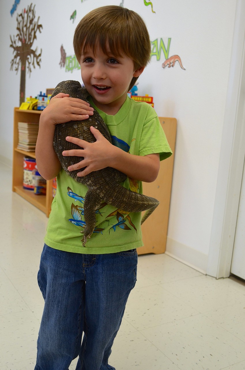 Brennon Bonnet, 4, makes friends with Savannah Monitor lizard, Sausage.