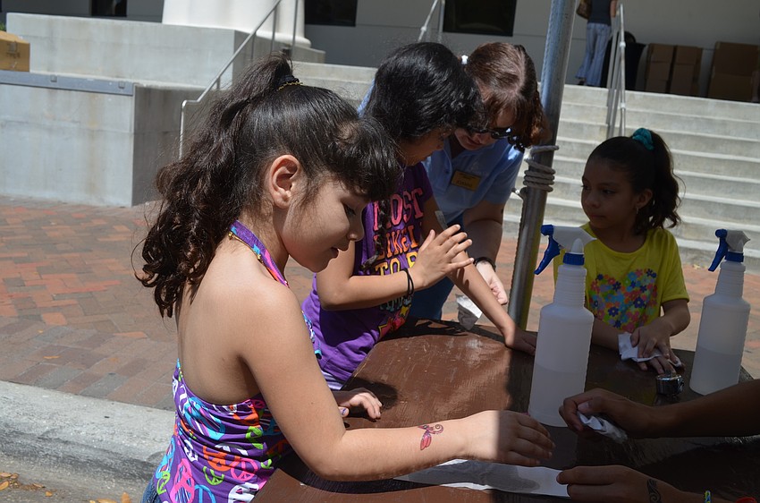 ; Miranda Rojo gets a dragonfly temporary tattoo.