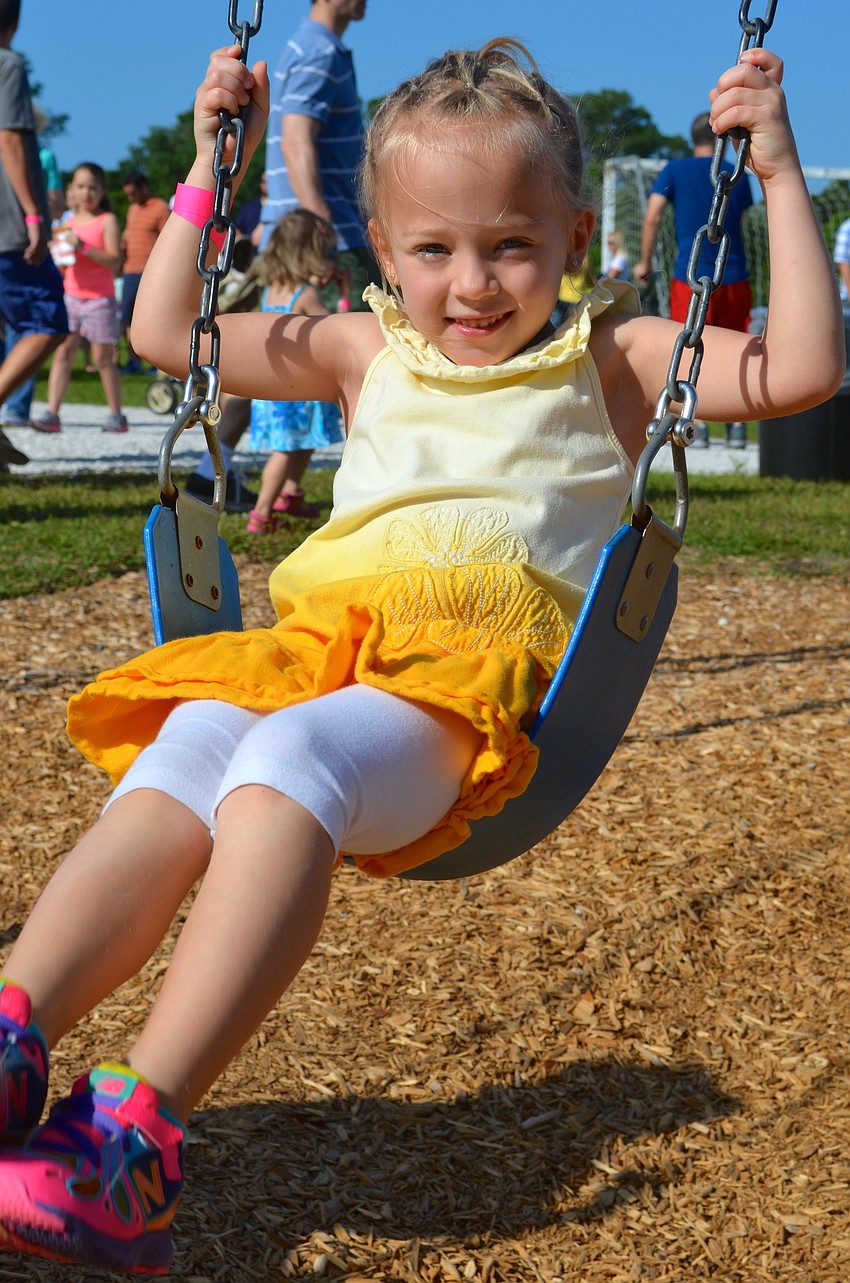Gabbie Hotaling, 5, swings while she waits for the festivities to begin.