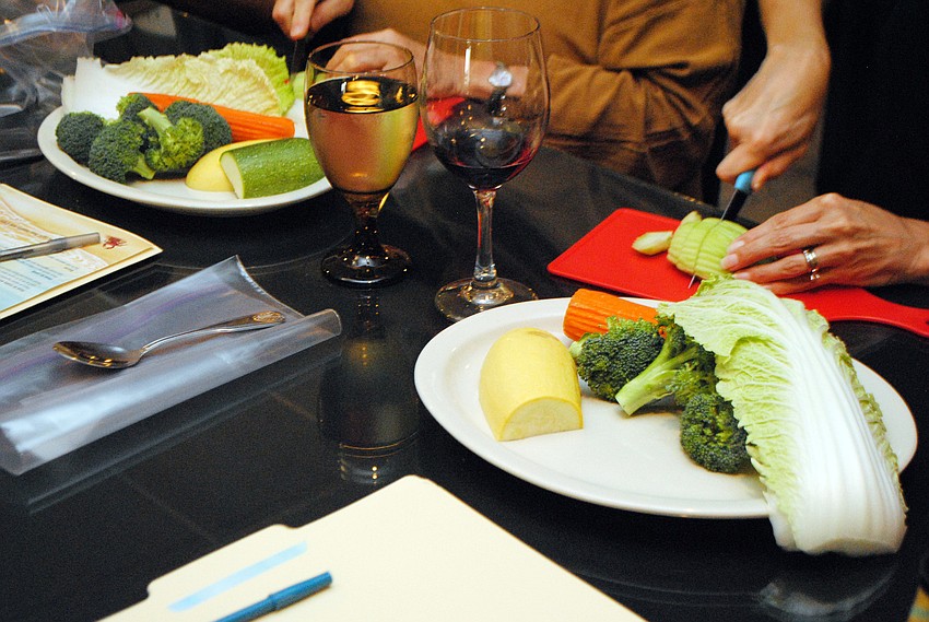 Students in Taste of Asiaâ€™s cooking class slice and dice vegetables.