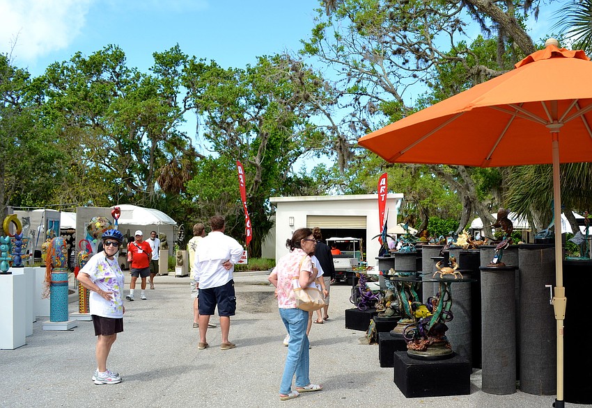 Festivalgoers wander around Longboat Key Clubâ€™s Tennis Gardens.