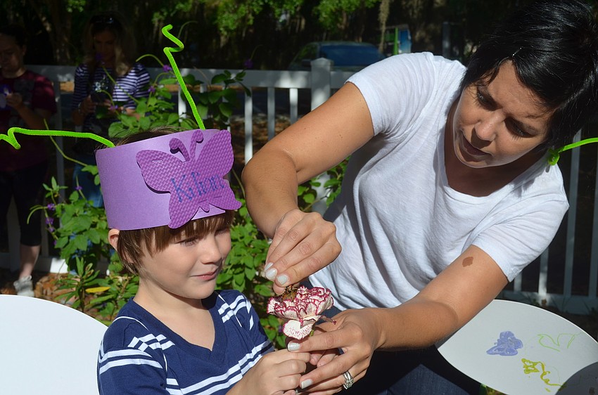 Kilian Viquerate watches Erin Bonifate place a butterfly on his flower.
