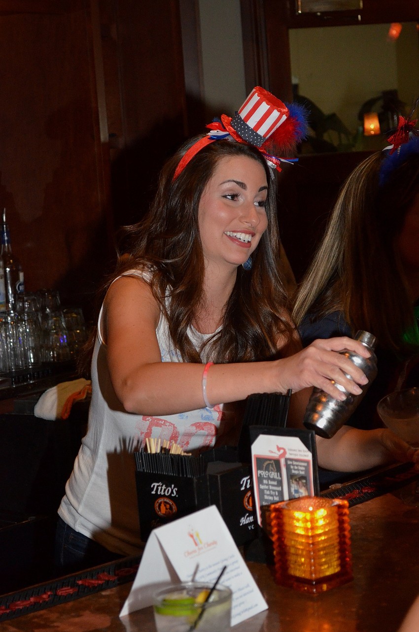 Janel Shinn, co-founder of Cheers for Charity, serves up a cocktail to an event guest.
