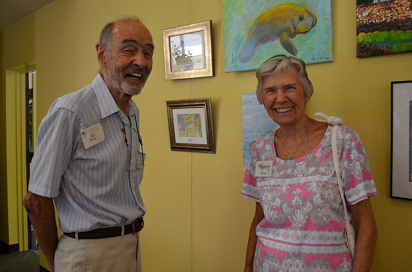 Bill Danner and Nancy Hinds browse the selection of watercolor paintings.