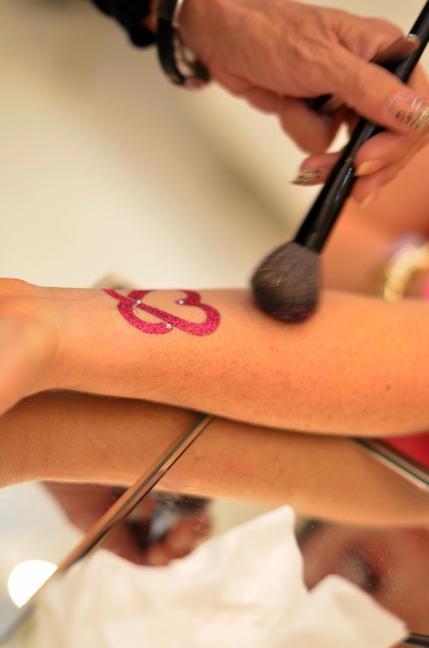 A glitter tattoo station was set up in the beauty department of Saks Fifth Avenue for guests to get themed breast cancer awareness tattoos at the event.