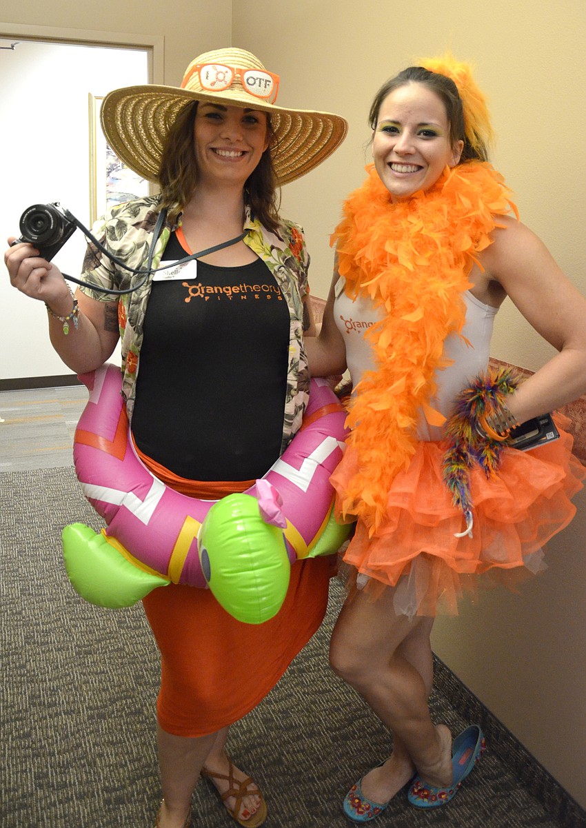 Shelley Schreiber and Kate Lanni with Orange Theory dressed up as a safari hunter and a parrot.