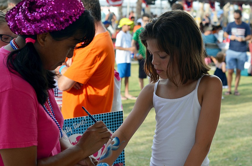 Addison Haylett gets her arm painted in the Kid Zone at the Siesta Key Chamber of Commerce's Fourth of July Fireworks Celebration VIP Party.