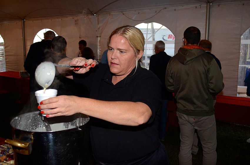 Karen Combs, of Polo Grill and Barâ€™s Fete Ballroom, pours clam chowder for attendees.