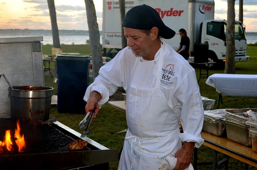 David Sargent prepares barbecue chicken for attendees.