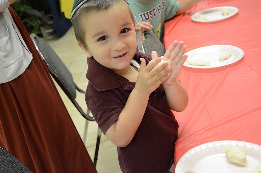 Shalom Ber Bukiet, 3, rolls dough into balls.