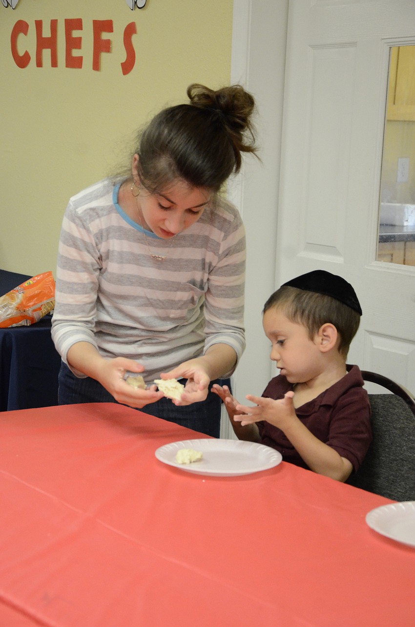 Counselor Rivkah Kessler helps out Shua Bukiet, 4.