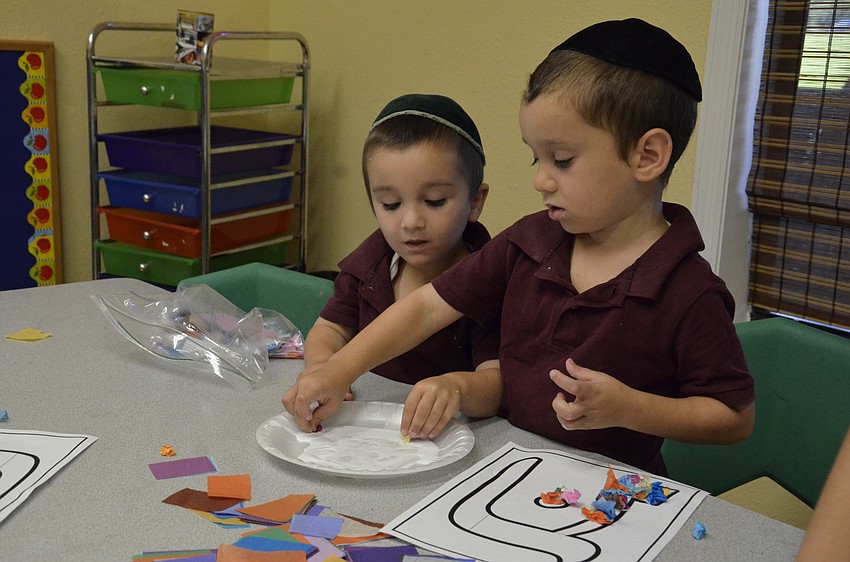 Brothers Shalom Ber Bukiet, 3, and Shua, 4, decorate an alphabet letter.