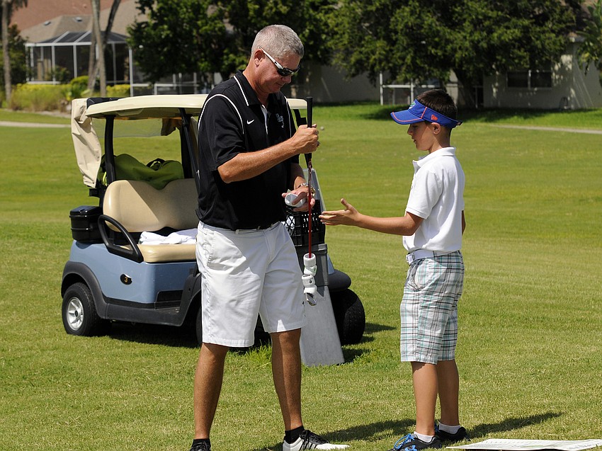 Dave Frantz offers pitching instruction to 10-year-old Michael Valentino.