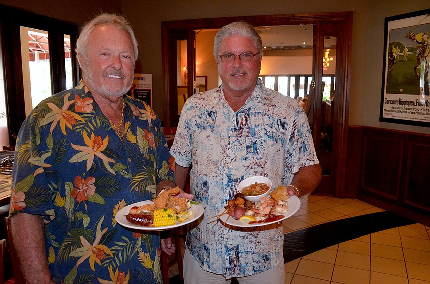 Jim Chapman and Larry Robinson sport matching smiles and tropical-themed shirts.