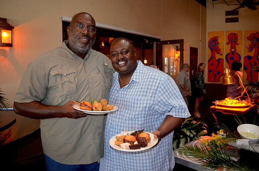Norman Stockton and Darrell Nixon fill their plates with Cajun food.